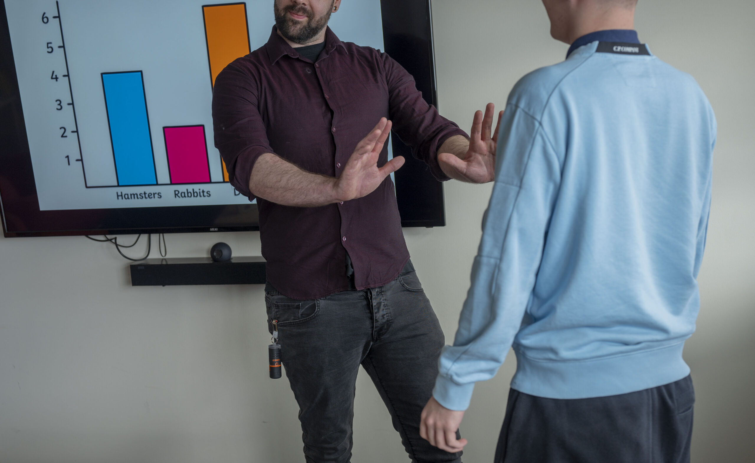 Teacher holds up hands toward approaching student