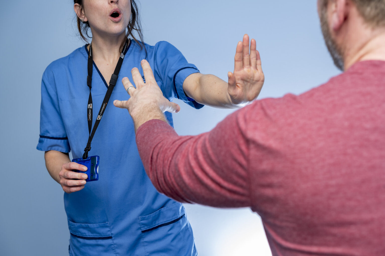 Nurse activates Pinpoint Badge PIT alarm as male makes aggressive gesture toward her.